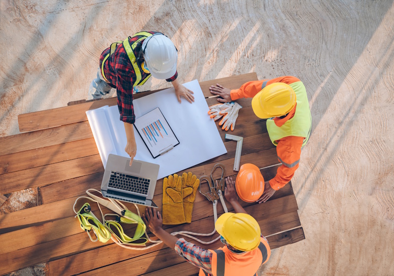 engineers standing around plans outside