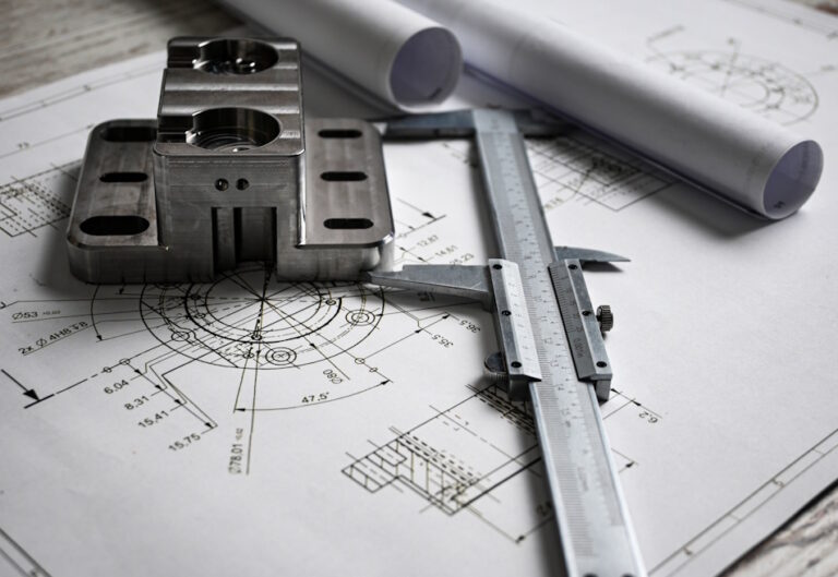 product engineer designs next to a tool and a prototype